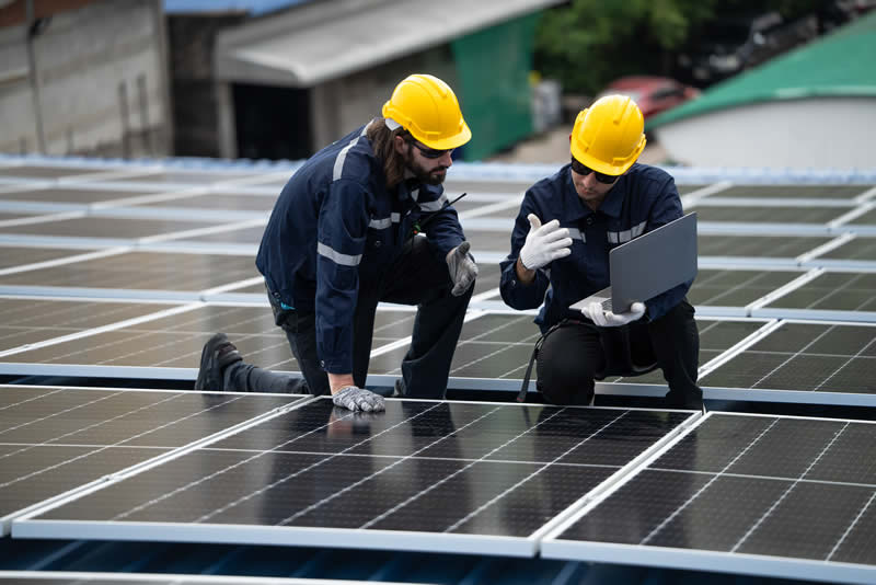 Two technicians working on solar panels.